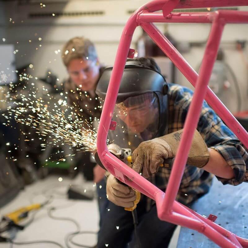 Students in Votey Hall performing an aero lab with sparks flying and safety gear on.