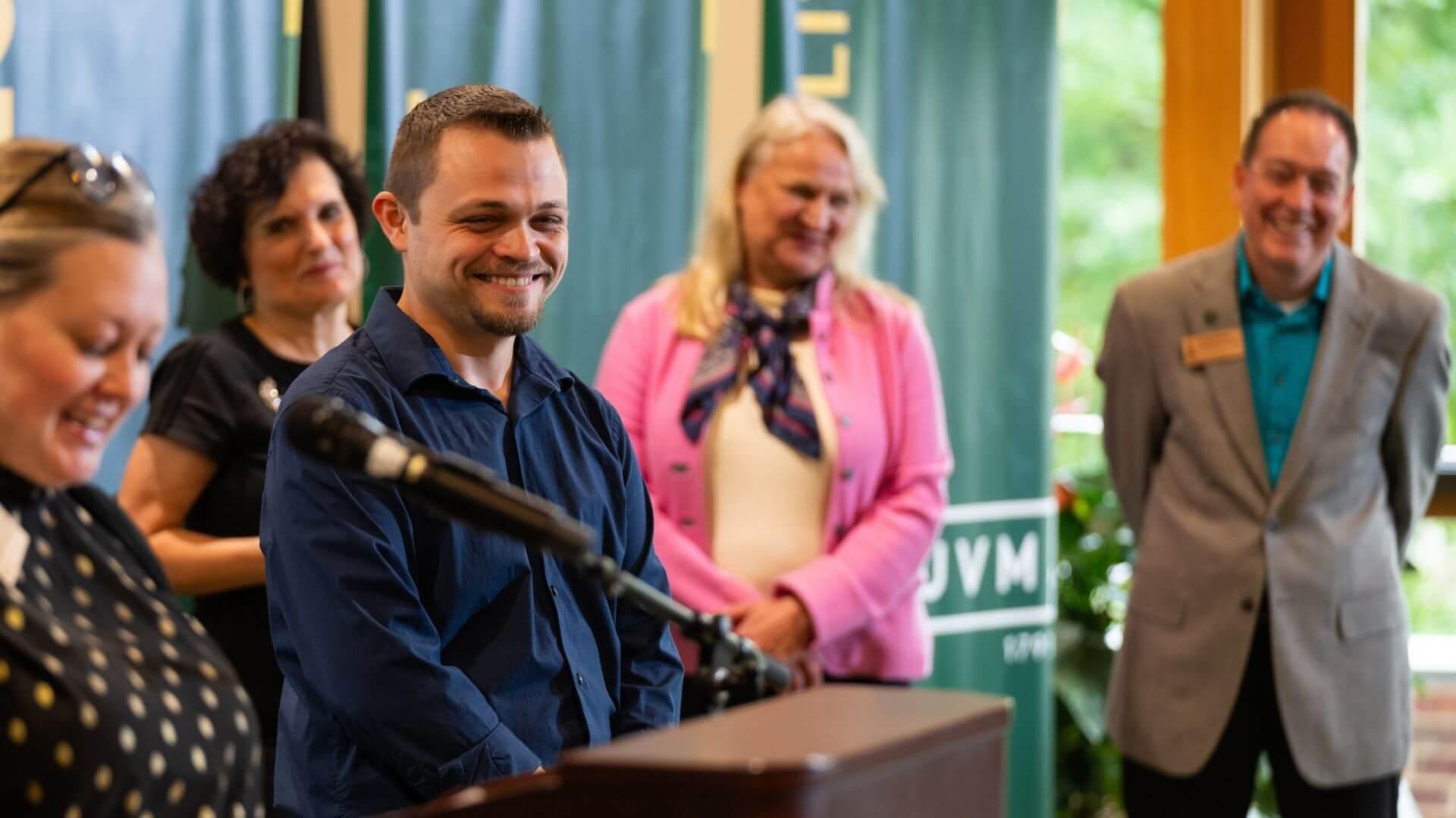 Our Common Ground Staff Award winner Justin Sell smiles and laughs while being presented his award