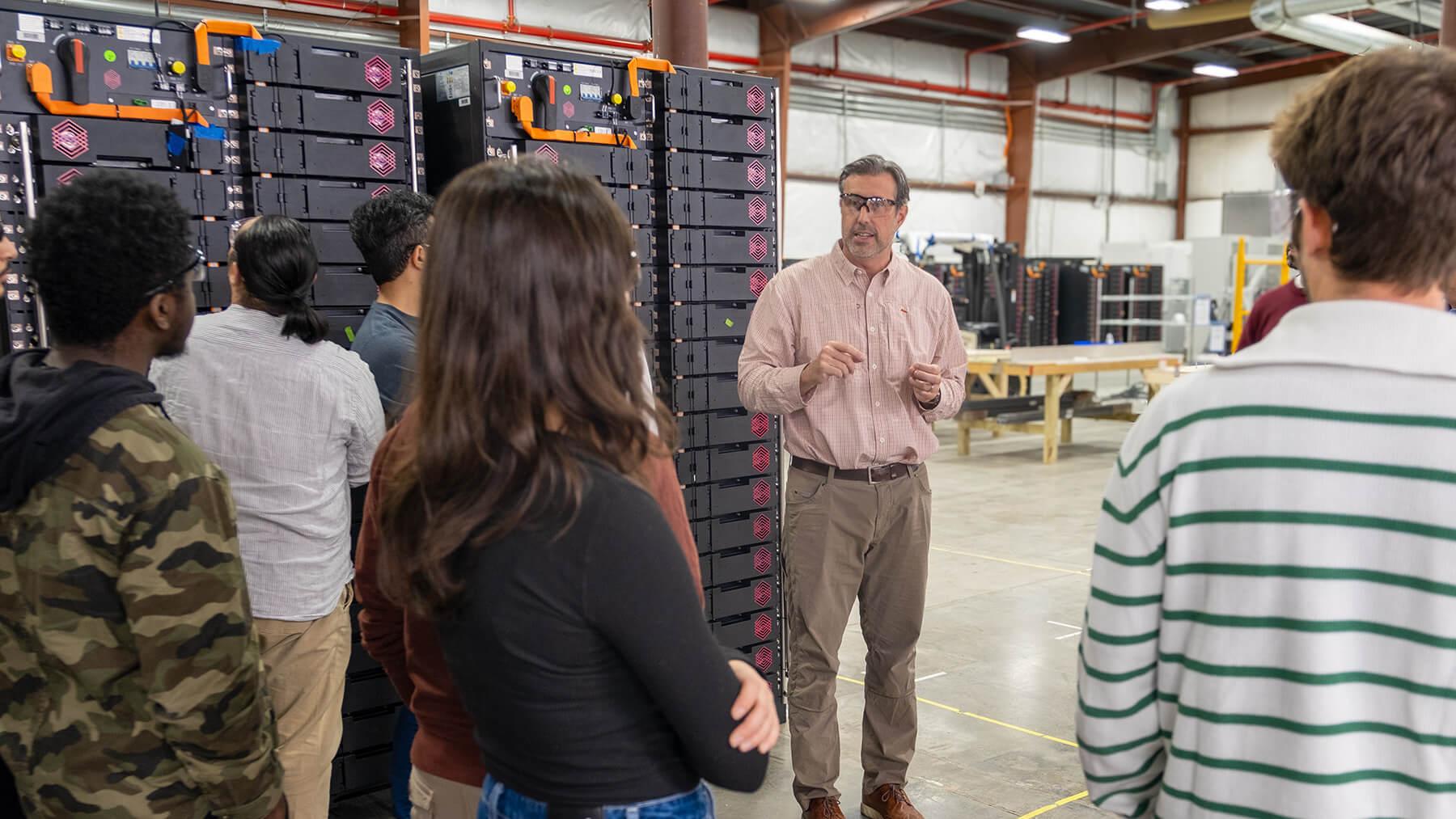 KORE President Jay Bellows guides a group of students and faculty through their manufacturing facility