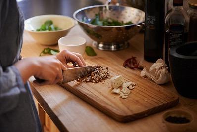 Hands chopping vegetables on a cutting board