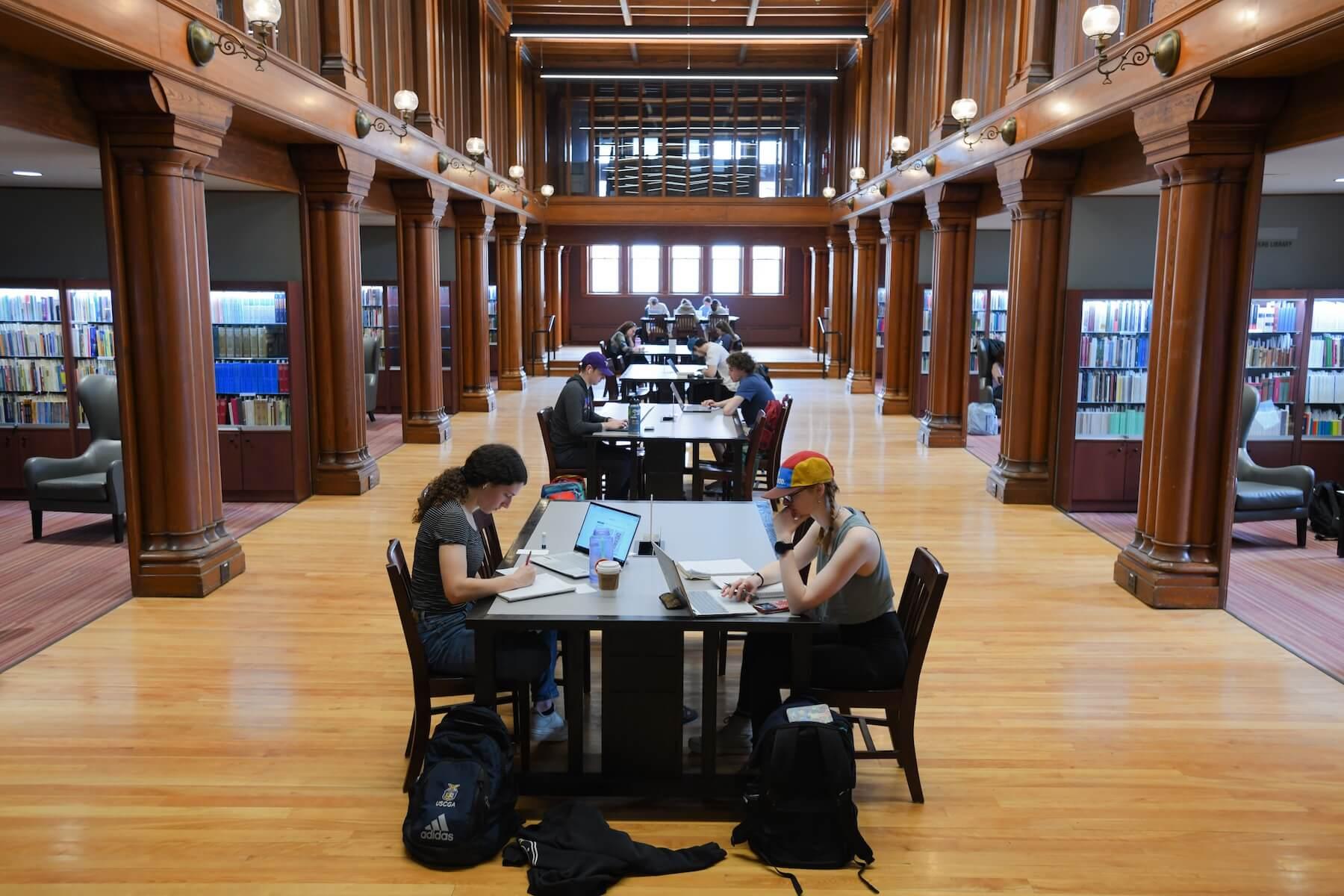 Students study in a grand hall.