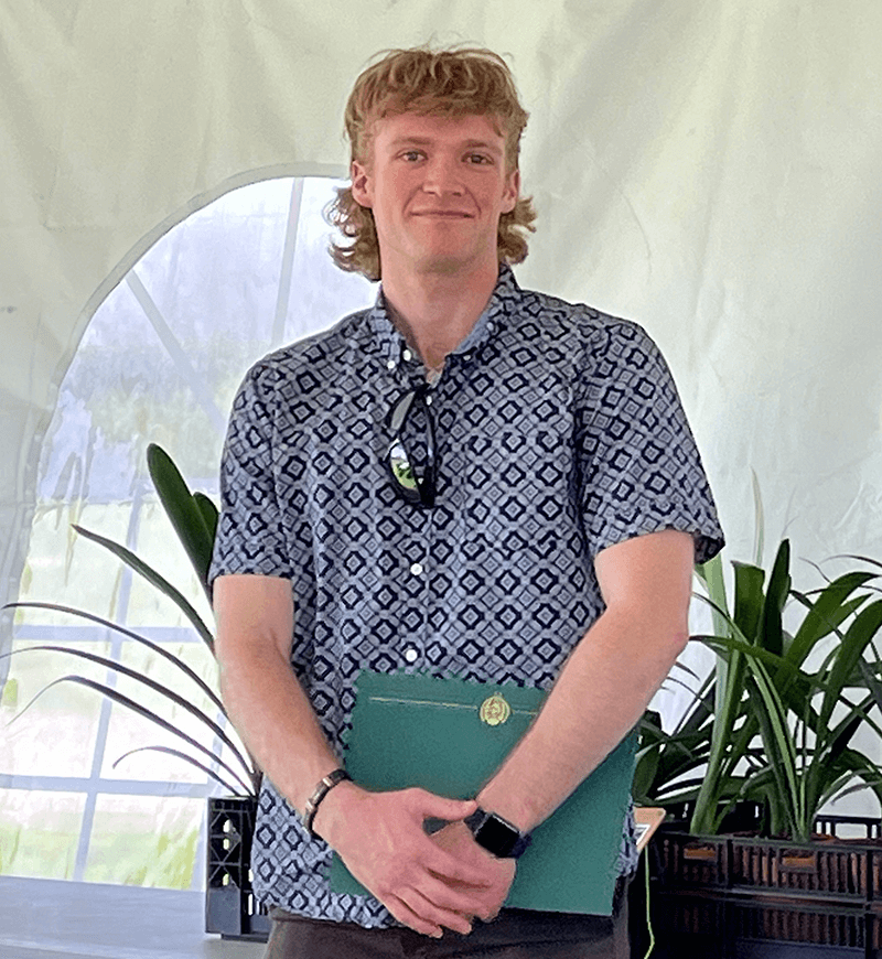 Smiling student holds award