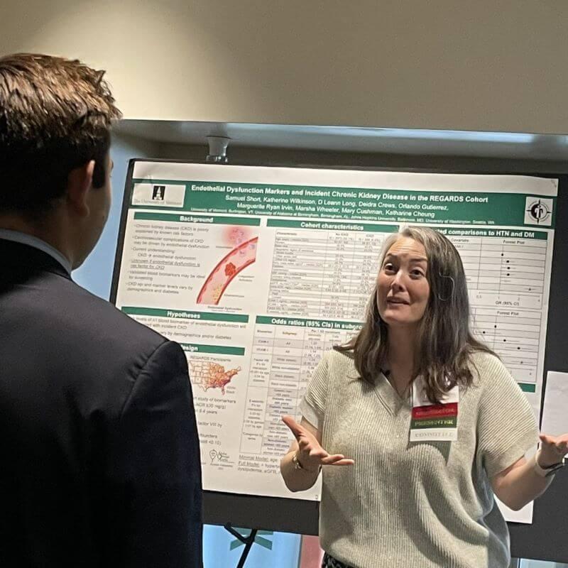 Researcher presenting a scientific poster to another person.