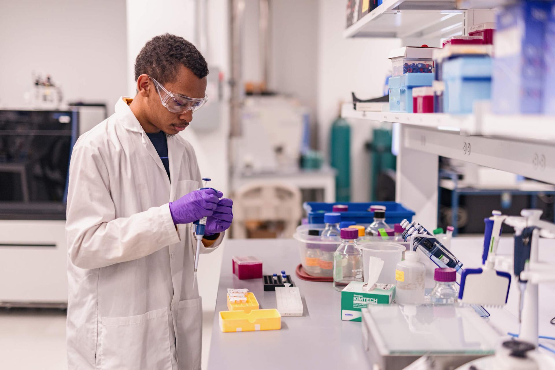 A person standing at a work space in a laboratory