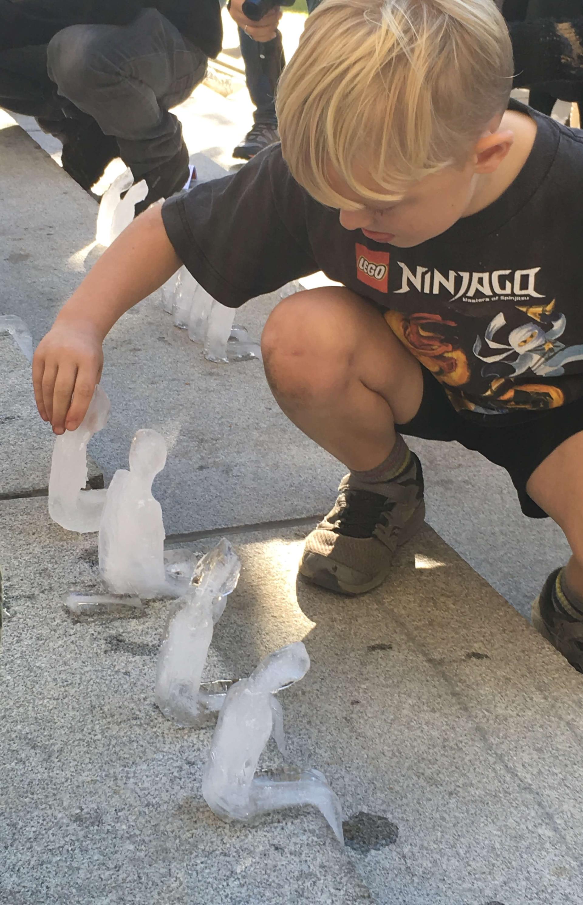 Kid playing with ice sculpture