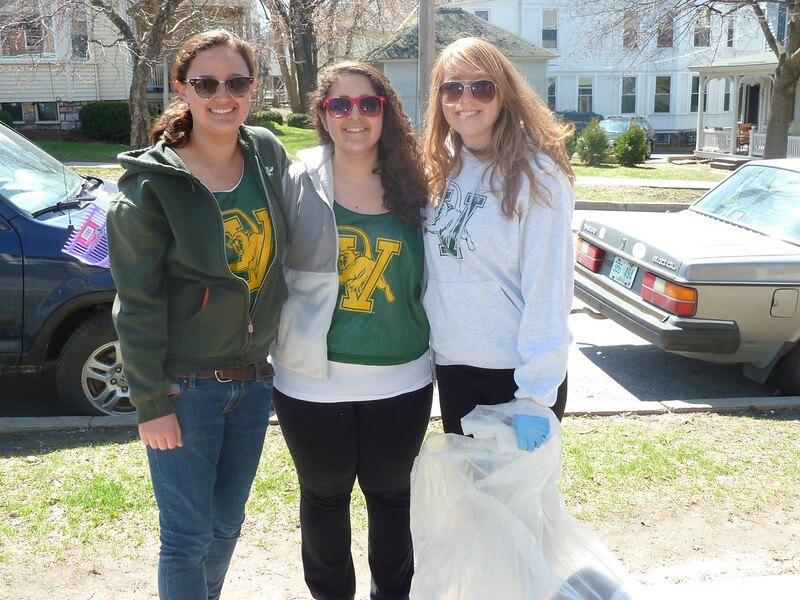 Group of students posing with the trash they collected during a neighborhood clean-up.