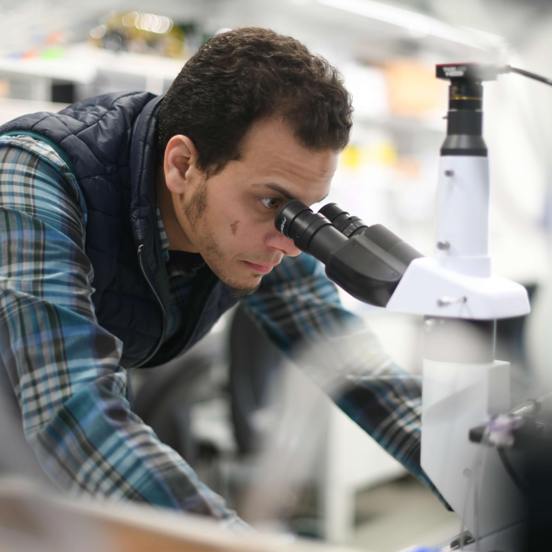 A researcher looking into a microscope.