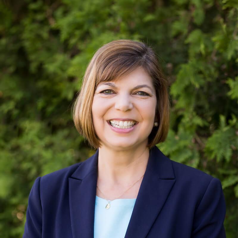 headshot of woman smiling in outdoor setting