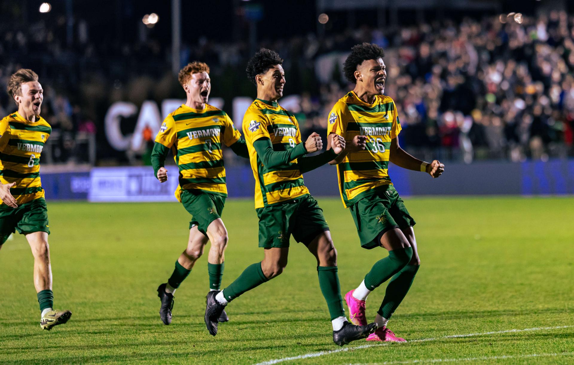 UVM men's soccer players celebrate a goal on the field