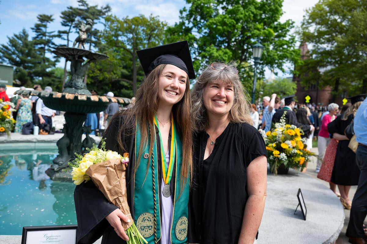 A graduating student poses with her family member