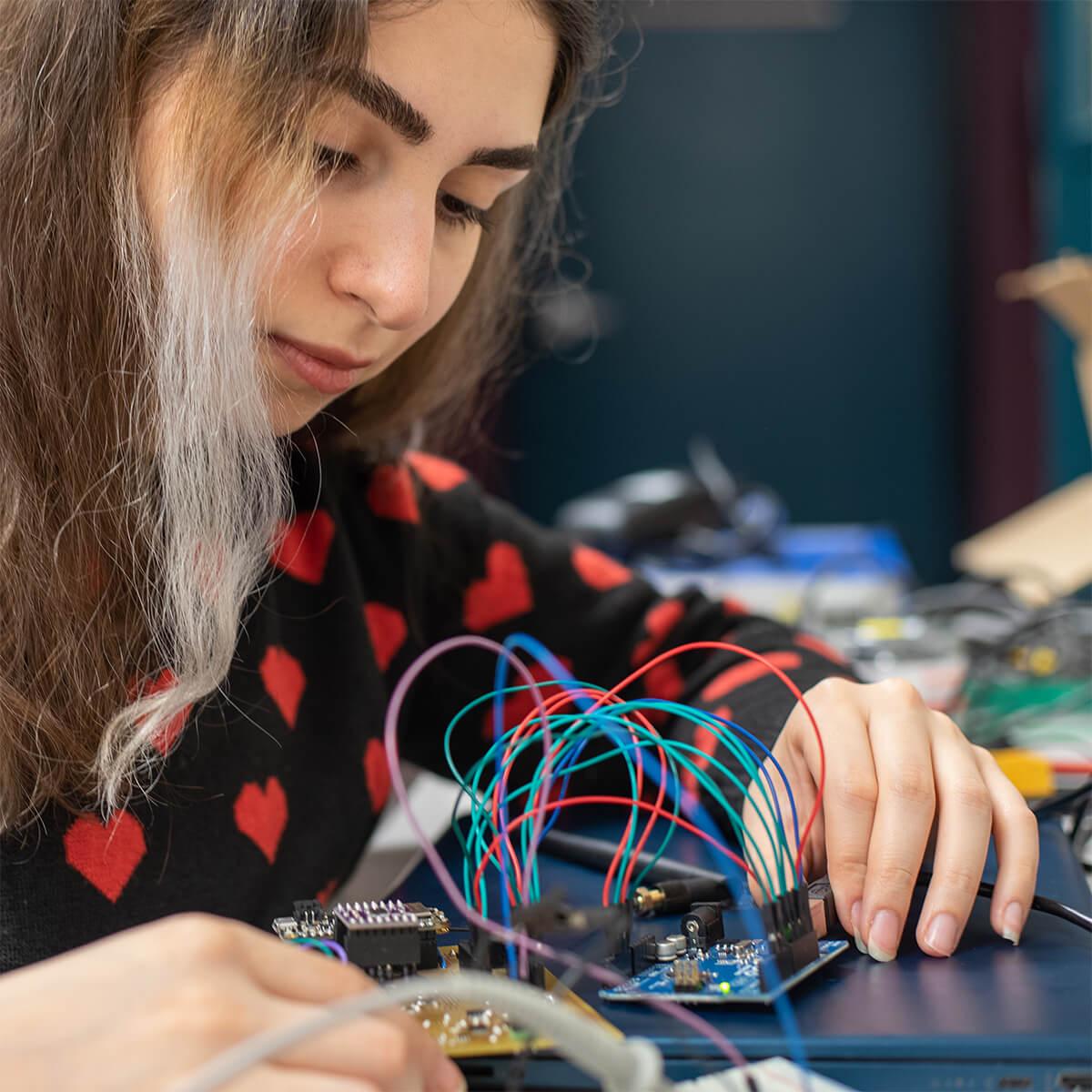 An engineering student looking at electronics