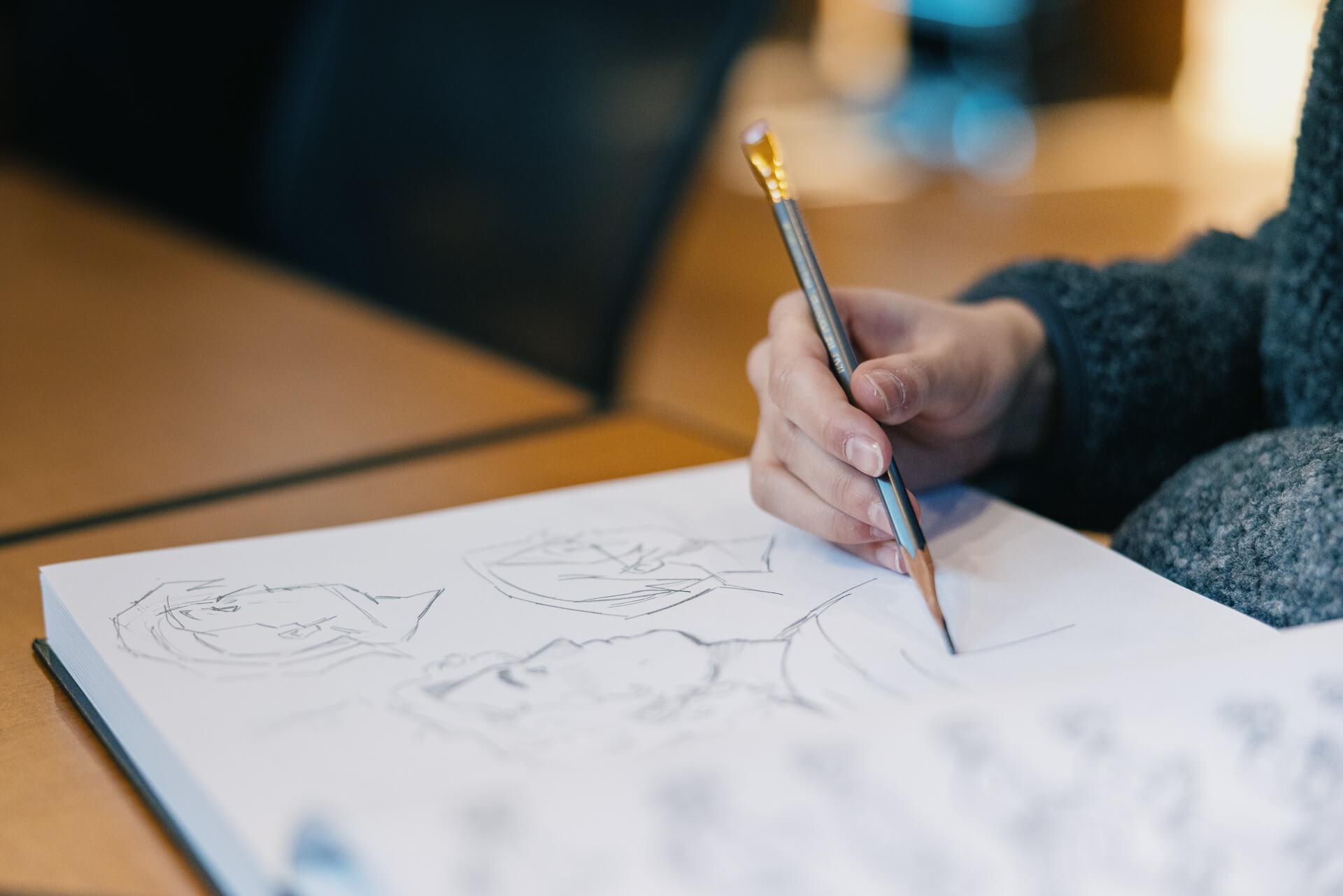 A student drawing comics in a notebook