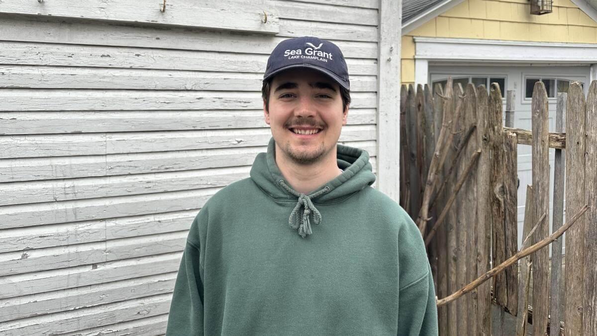 Gus standing outdoors in a Lake Champlain Sea Grant ball cap.