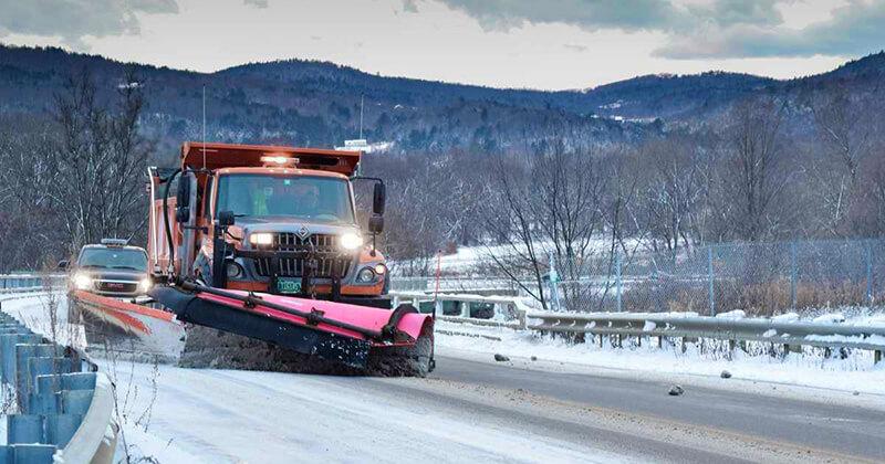 Snowplow clearing roads in Vermont on a snowy day