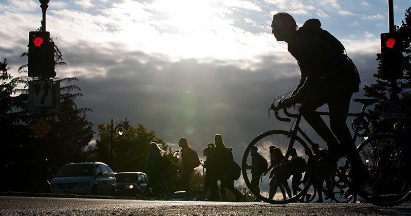 Cyclist and pedestrians at a campus crosswalk