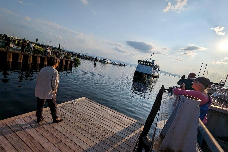 Ellen standing on the boat dock watching the new Research Vessel arrive in Burlington by water