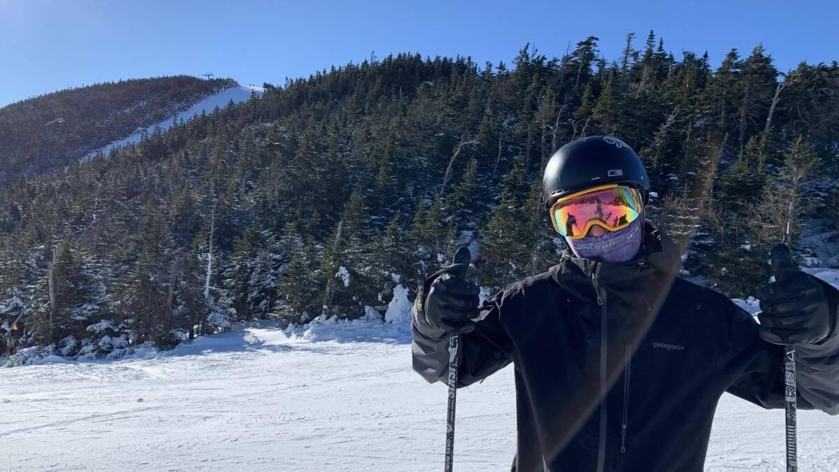 Gus putting two thumbs up while on a ski mountain.