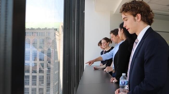 Accounting students look out the window of a Boston high-rise 