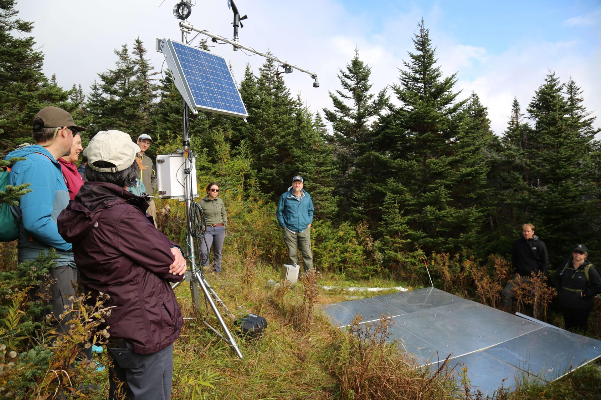 Researchers look at a weather monitoring station