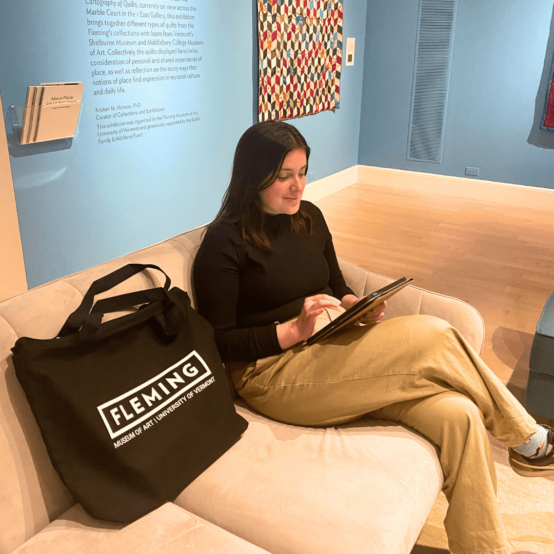 Sarah Stevens '25 sits with a Fleming tote in the West 1 gallery.