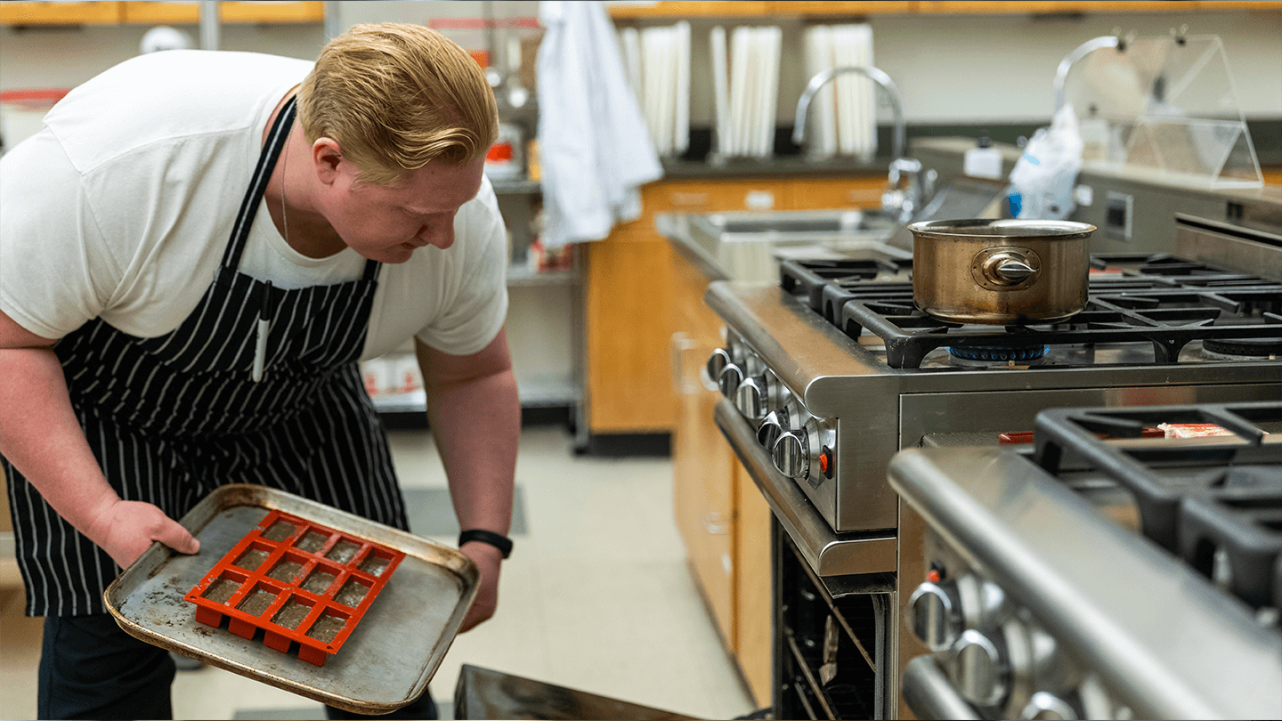 Baker putting tray into oven