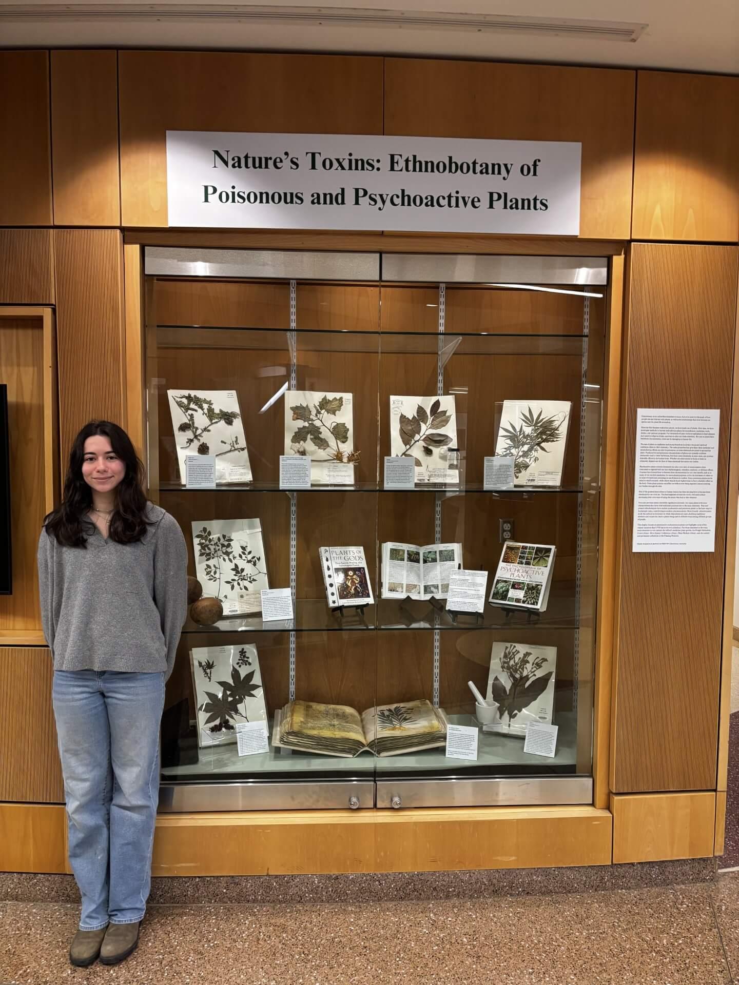 Kylie standing next to display case