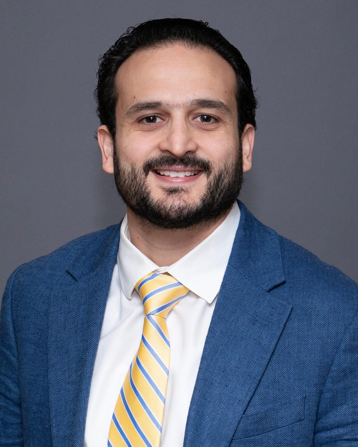 Researcher smiling posed against a grey background