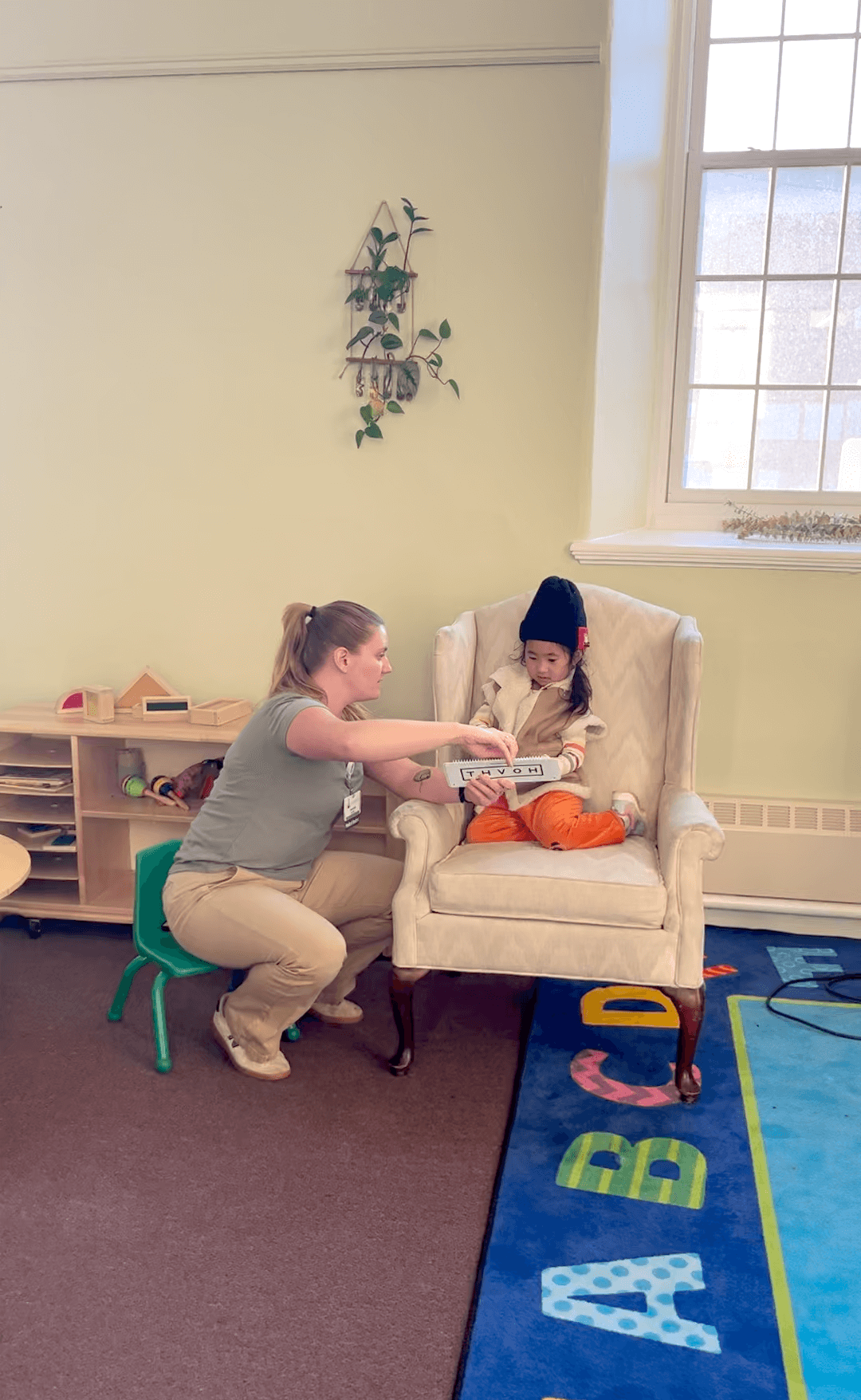 An adult helps a young child to read