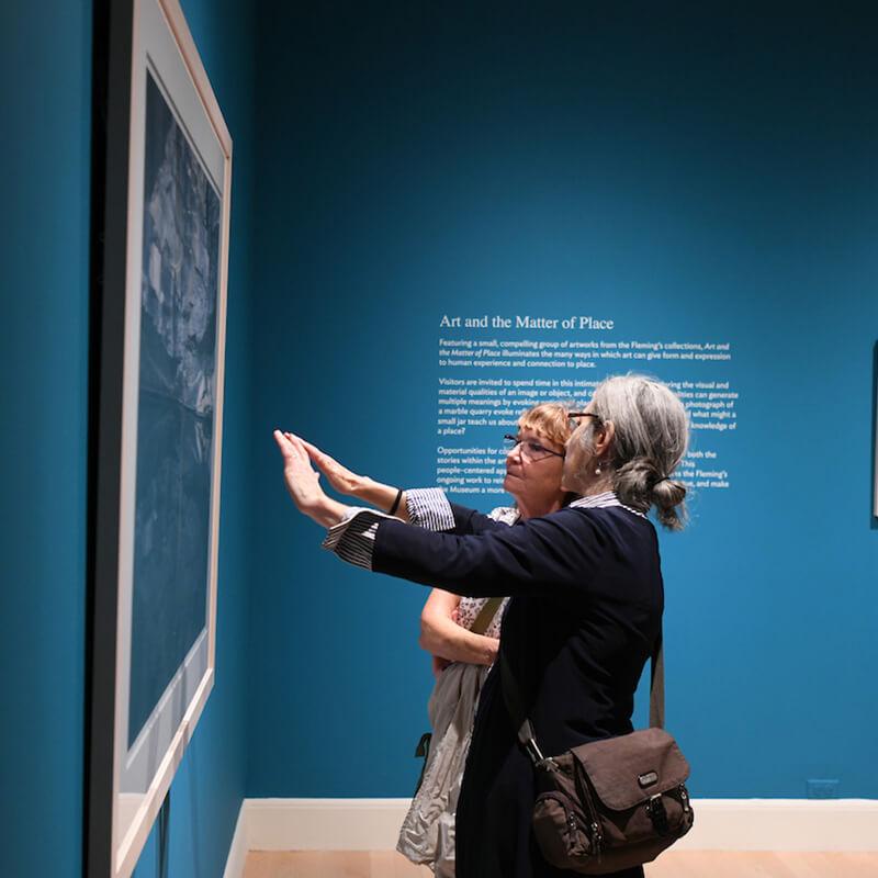 Two women observing a painting in an art museum
