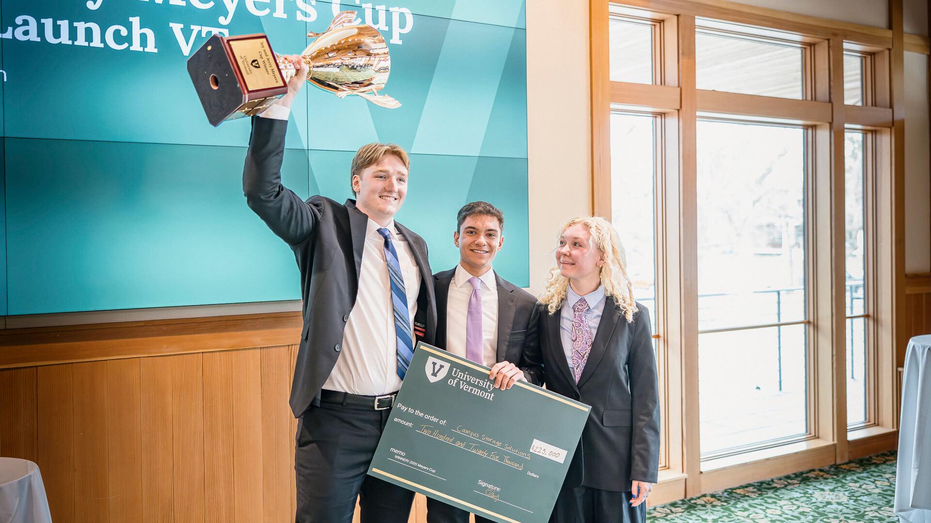 Logan Vaugn, Ethan Israel, and Alley Updegrove holding the Meyers Cup trophy and a large check for the cash prize