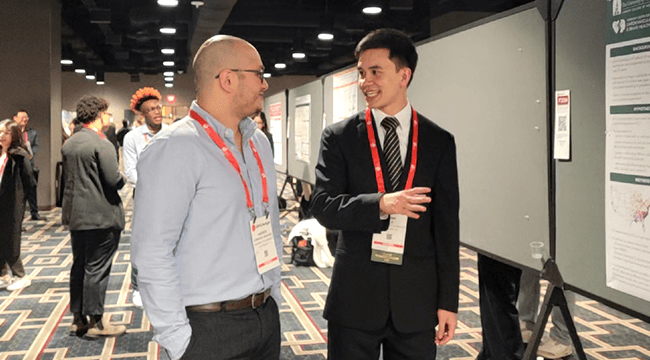 people talking at a conference poster session