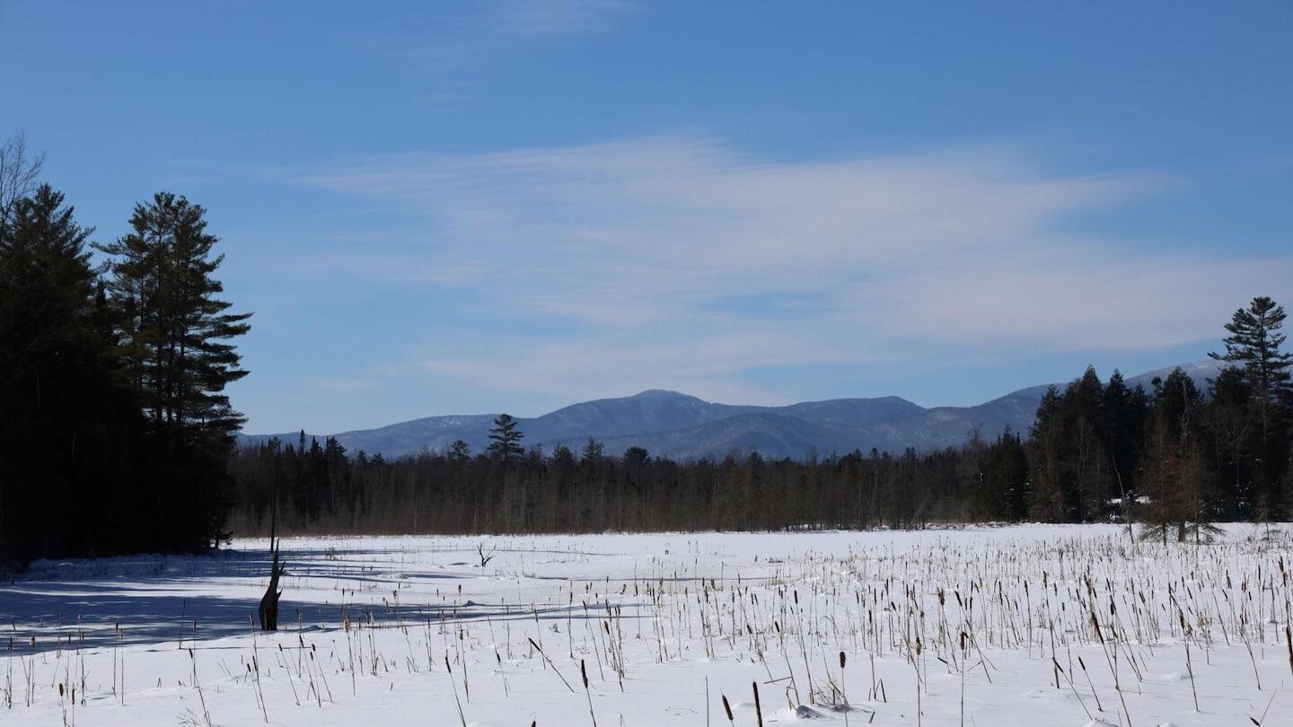 View of frozen Joe's Pond with mountains in the distance
