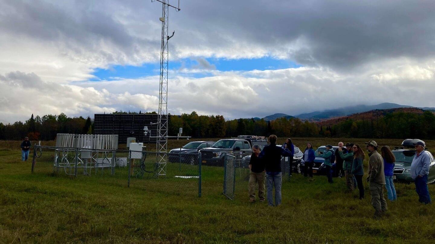 A crowd of people gather at a weather station