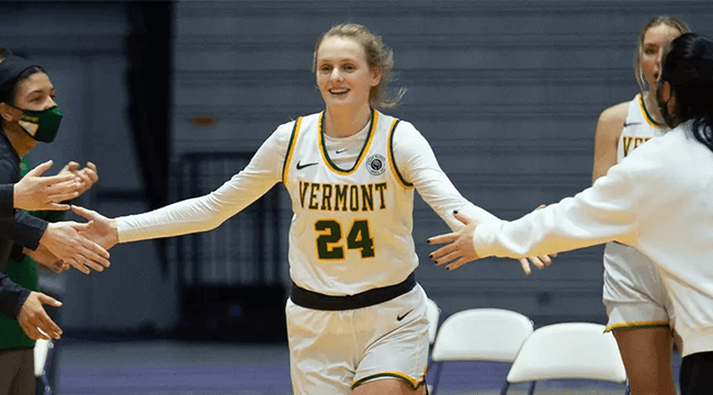 a woman basketball player being greeted by fans on the court