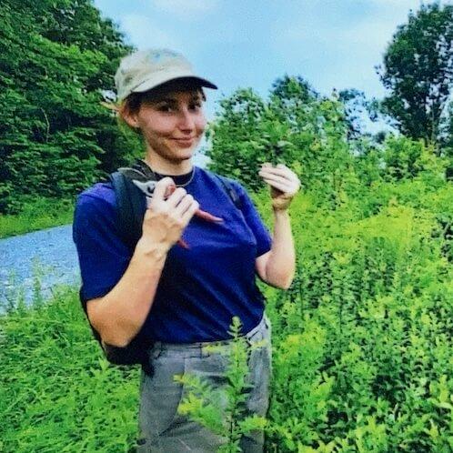 Veronica taking plant cuttings in the field