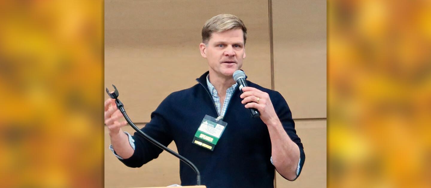 mark isselhardt holding a microphone and speaking