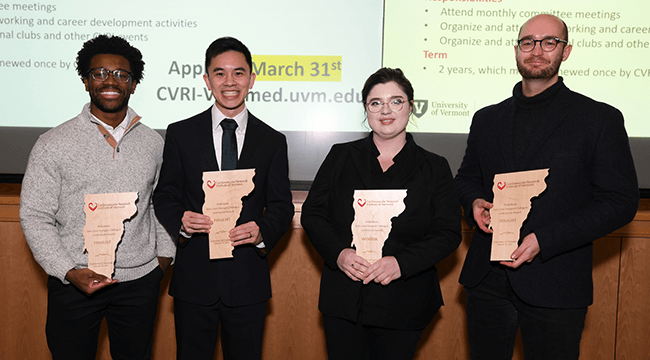 4 people standing with award plaques