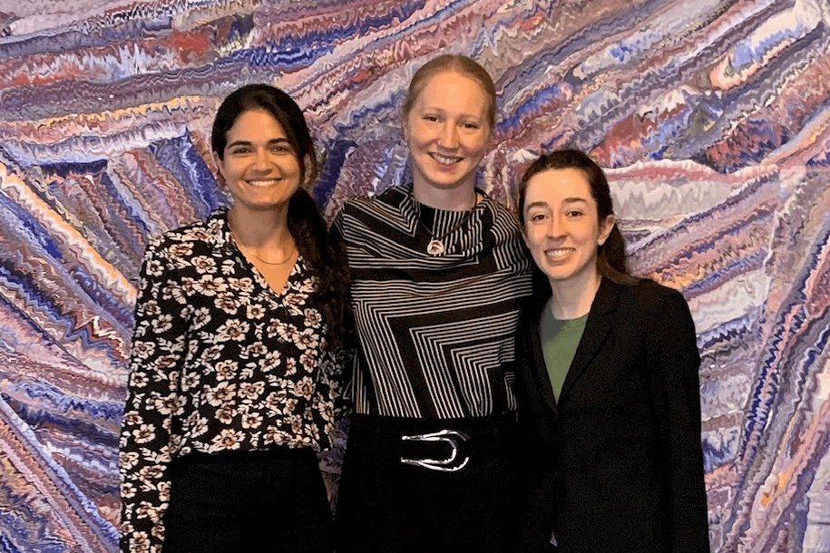 3 smiling women against a colorful background