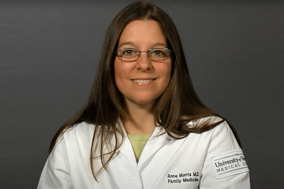 a woman in a white coat smiling