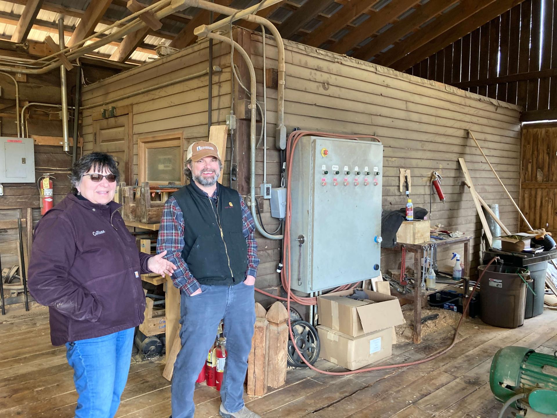 two people standing in a sawmill