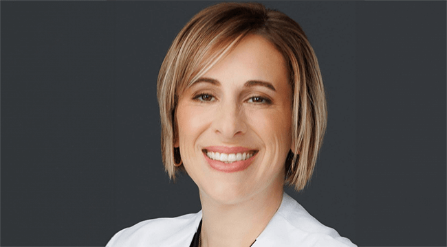 a woman in a white coat smiling