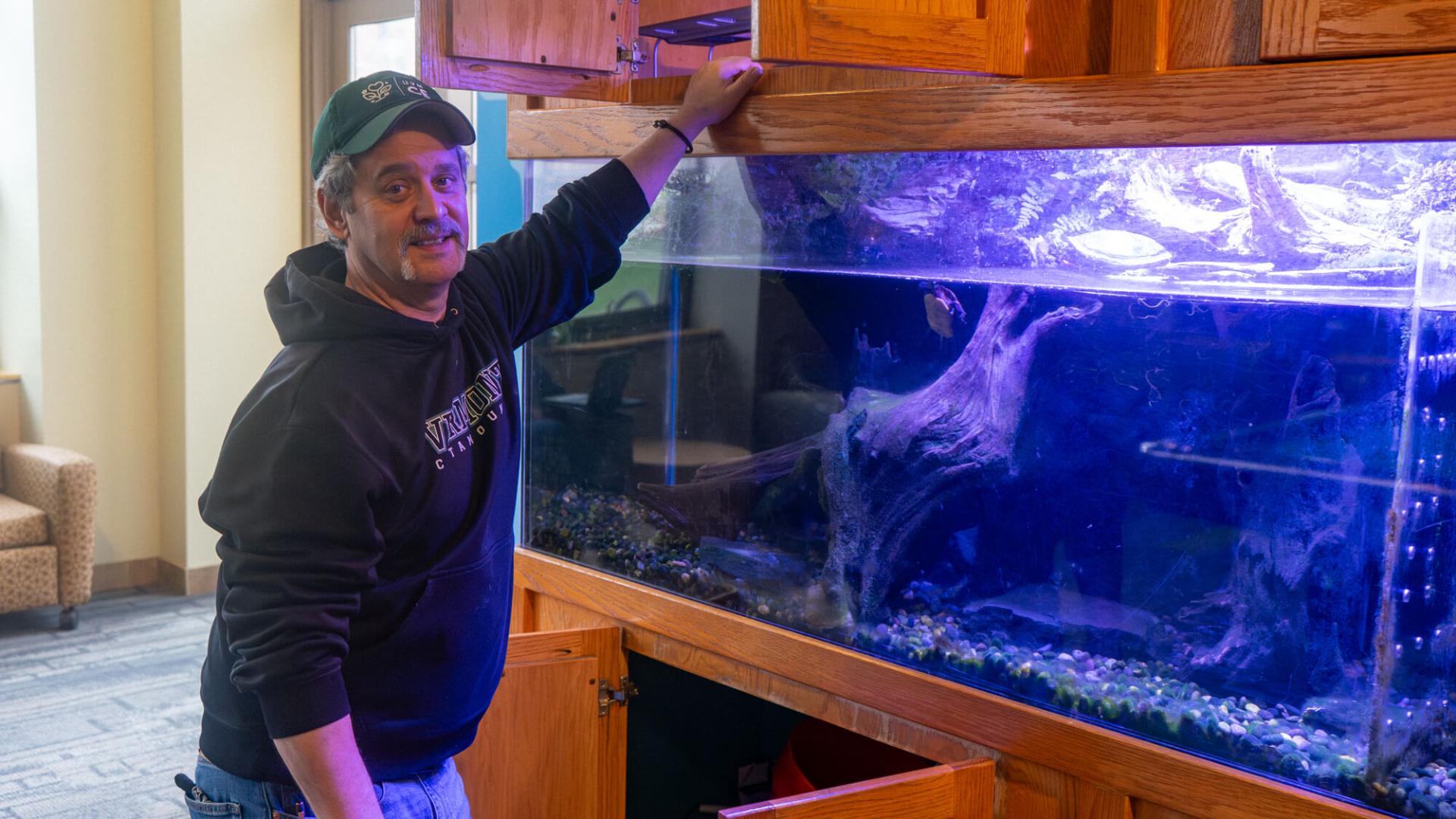 Kyle Warren smiles while working on the turtle tank