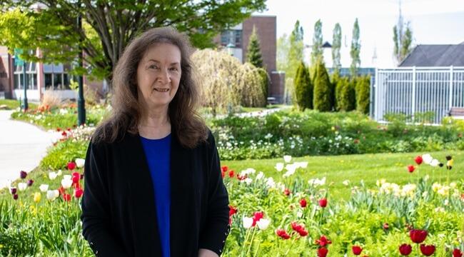 Pat Stokowski standing in front of a tulip garden at UVM