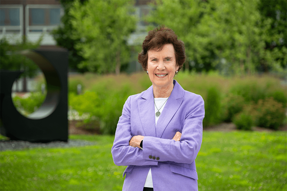 a woman in a lilac jacket smiling