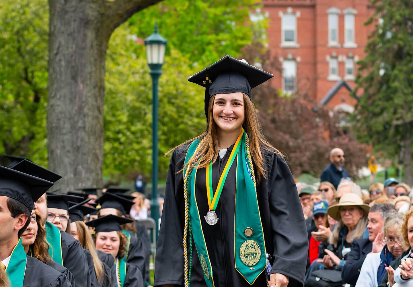 Maggie Sorrentino walks to the stage to receive her student leadership award at UVM Commencement in 2023.