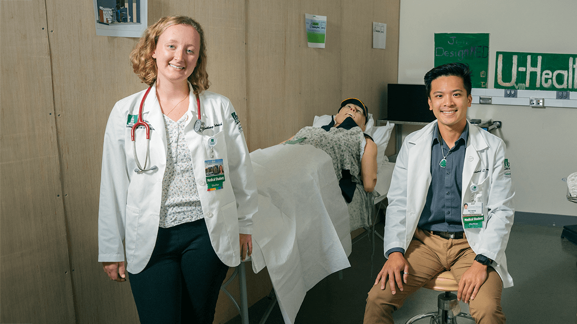 Lindsay Aldrich (left) and Richard Vuong pose for a photo in the mobile health clinic mockup in UVM’s Center for Biomedical Innovation.