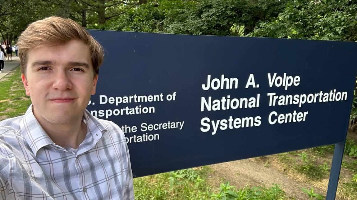Chris Lamm standing in front of a Department of Transportation sign