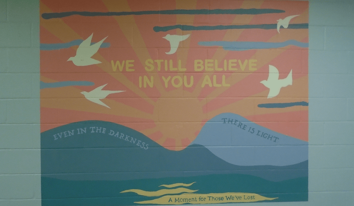 We still believe in you banner on a wall painted bright blue