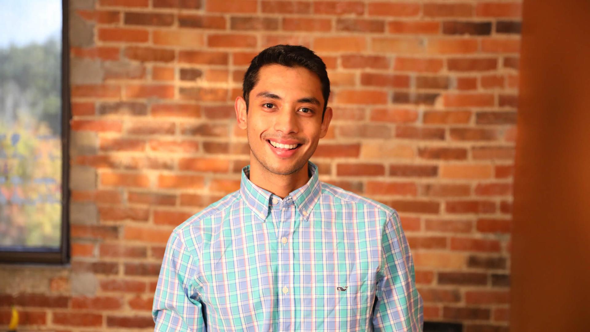 Shuvan Shrestha '21 standing in front of brick wall