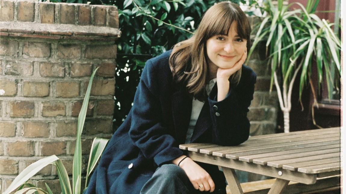 Author Adrienne Buller sits at a table